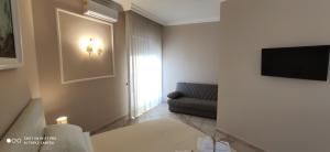 a living room with a couch and a television on a wall at GIOIArooms in Trani