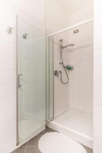 La salle de bains est pourvue d'une douche avec une porte en verre. dans l'établissement B&B Entro Le Mura, à Bergame