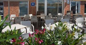 un patio al aire libre con mesas, sillas y flores en Iraipe Izaga Hostal, en Noáin