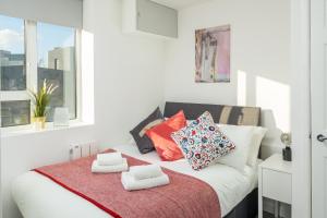 a bedroom with a white bed with pillows on it at Skyline Serviced Apartments - Vauxhall in London