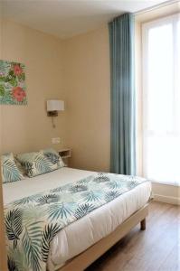 una camera con letto e finestra di Hotel Le Havre Bleu a Beaulieu-sur-Mer