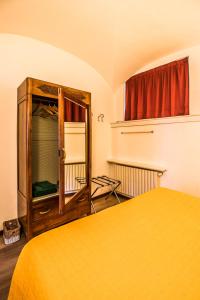 1 dormitorio con cama amarilla y espejo en B&B Entro Le Mura, en Bérgamo