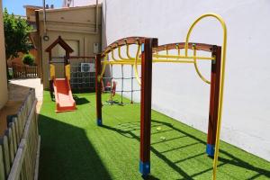 un parque infantil en un patio con césped verde en RVHotels Apartamentos Provenzal, en L'Escala