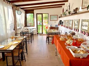un restaurante con mesas largas y sillas con comida. en B&B Villa Vittoria, en Giardini Naxos