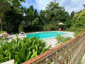 a bridge over a swimming pool in a garden at Villa Riviera Chambres Privées in Amélie-les-Bains-Palalda