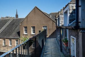 a balcony of a building with a fence and buildings at Modern Grassmarket Apartment in Edinburgh