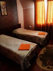 a room with two beds with orange napkins on them at Ідилія in Zhensna Polʼska