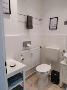 un bagno bianco con un water e un lavandino di City-Apartment Perle a Bremerhaven Altre 14 foto