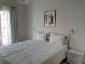 a bedroom with a large bed with white sheets at Mare Monte in Ios Chora