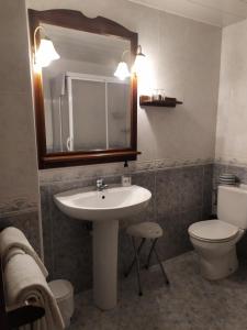 a bathroom with a sink and a toilet and a mirror at Turisme rural Can Genis in Peralada