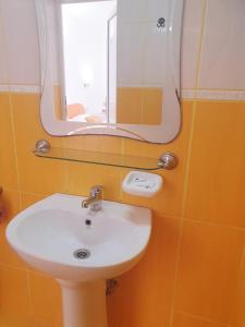 ein Badezimmer mit einem weißen Waschbecken und einem Spiegel in der Unterkunft Vila Fery Costinesti in Costinești
