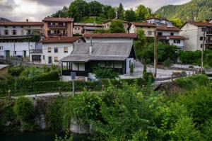 un groupe de maisons dans une ville à côté d'une rivière dans l'établissement Holiday house Tinca, à Most na Soči
