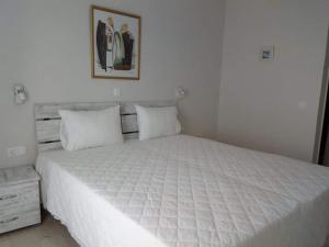 a bedroom with a large white bed with white sheets at Mare Monte in Ios Chora