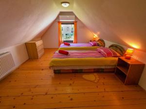 - une chambre mansardée avec 2 lits et une fenêtre dans l'établissement Holiday house Tinca, à Most na Soči