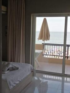1 dormitorio con cama y vistas al océano en Pantheon Beach Hotel, en Olympiakí Aktí