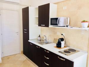 una piccola cucina con lavello e microonde di casa La sorgente di Carlo Magno a Otranto Altre 33 foto
