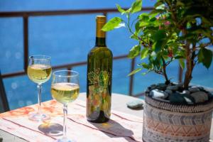 Una botella de vino y dos copas en una mesa. en Effies House en Kalymnos