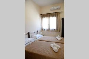 1 dormitorio con 2 camas y toallas. en Effies House en Kalymnos