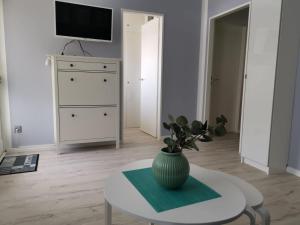 a living room with a vase on a table at City-Apartment Perle in Bremerhaven