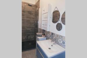 uma casa de banho com um lavatório e 2 espelhos em gite Pedelucq em Pouillon