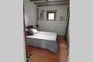 Bett in einem kleinen Zimmer mit Fenster in der Unterkunft gite Pedelucq in Pouillon