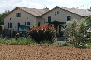 une maison blanche avec quelques buissons devant elle dans l'établissement gite Pedelucq, à Pouillon