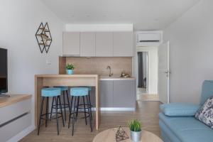 a kitchen and living room with a counter and stools at IvMaLu Apartments in Tučepi