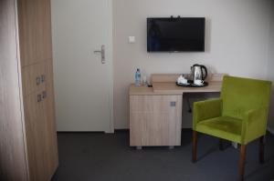 een kamer met een bureau en een groene stoel bij Stara Cynkownia in Czechowice-Dziedzice