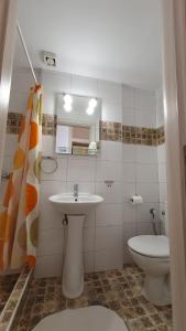a white bathroom with a sink and a toilet at Haus Maria in Nea Potidaea +58 photos
