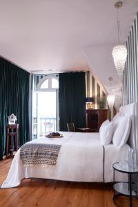 a bedroom with a large white bed with green curtains at Chateau de Sacy in Sacy