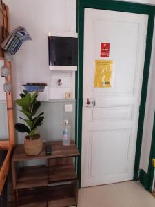 a room with a white door and a table with a plant at La Villa des Thermes in Le Mont-Dore
