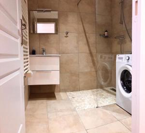 a bathroom with a washing machine and a washer at Apartmán Provence in Doksy