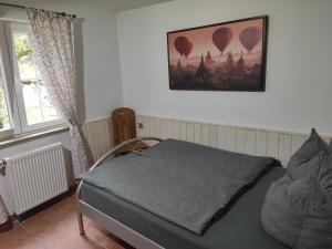 um quarto com uma cama e uma fotografia de balões de ar quente em Ferienhaus Schwarzwald Seewald Erzgrube Badesee 100% Natur em Seewald