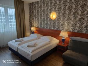 ein Hotelzimmer mit einem Bett und einem Sofa in der Unterkunft Hotel Atrium Charlottenburg in Berlin