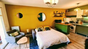 um pequeno quarto com uma cama e uma cozinha em Résidence du Haurat em Gujan-Mestras
