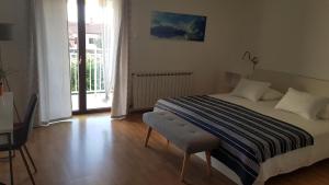 a bedroom with a bed and a table and a window at Apartments & Rooms Tom in Medulin