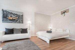 una camera da letto con un letto bianco e un divano di Under A Fig Tree Apartment a Lisbona