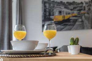 un tavolo con due bicchieri di succo d'arancia e un piatto di Under A Fig Tree Apartment a Lisbona