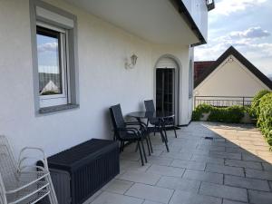 eine Terrasse mit Stühlen, einem Tisch und einem Fenster in der Unterkunft Ferienhaus Irene in Vogtsburg