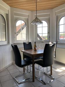 a dining room with a table and chairs and windows at Ferienhaus Irene in Vogtsburg