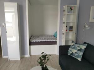 ein Wohnzimmer mit einem Sofa und einem Bett in der Unterkunft City-Apartment Perle in Bremerhaven