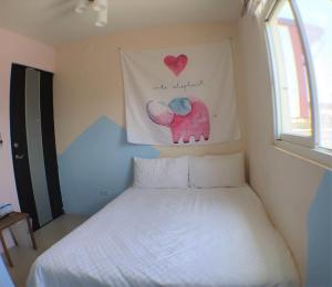 a bedroom with a bed with a picture of an elephant at 萩閣民宿Sara's House走路可到夜市近市區好停車 in Hualien City