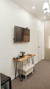Habitación con mesa y TV en la pared. en 7 Boutique Hotel, en Öskemen