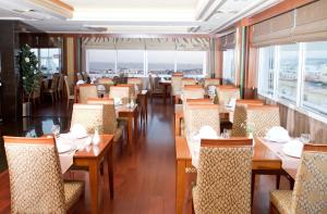 a restaurant with wooden tables and chairs and windows at Oran Hotel in Istanbul