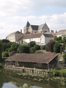 a group of buildings on a hill next to a river at La Bretauche in Chécy