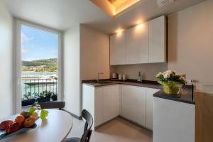 a kitchen with white cabinets and a table and a window at Al Gabbiano "Suite" in Portovenere