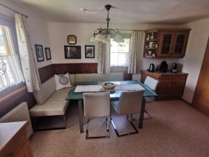 a dining room with a table and chairs and a couch at Haus Helga in Uttendorf