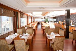 un ristorante con tavoli e sedie in legno e finestre di Oran Hotel a Istanbul