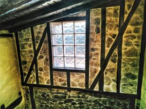 - une fenêtre dans un bâtiment avec un mur en pierre dans l'établissement Casa rural La Villa, à Miranda del Castañar