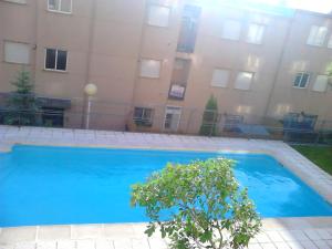 a large blue swimming pool in front of a building at Sol de Poniente in Salamanca +11 photos